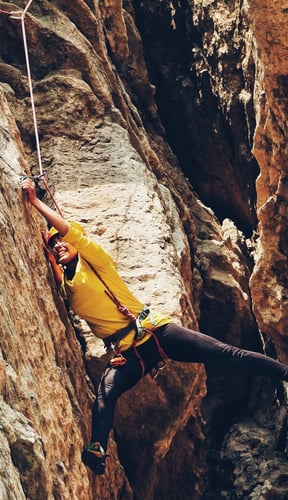 Rock climber ascending a canyon wall in Moab